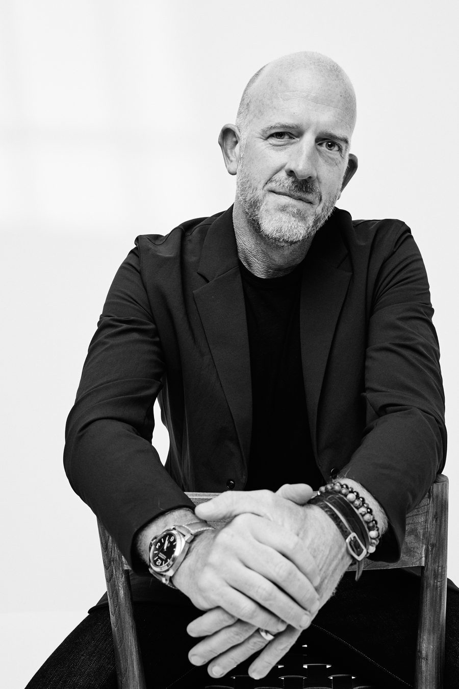Justin Chenetski, seated, in a black blazer